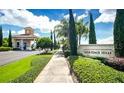 Community entrance featuring a gatehouse, lush landscaping, and the Heritage Hills sign at 3574 La Jolla Dr, Clermont, FL 34711