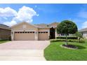 Charming single-Gathering home featuring a brick driveway, two-car garage, and well-manicured landscaping at 3574 La Jolla Dr, Clermont, FL 34711
