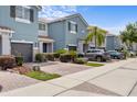 View of a row of charming blue townhomes, each with a private garage and beautiful landscaping at 366 Reed Grass Dr, Oviedo, FL 32765