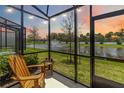 Screened-in patio featuring a serene view of the lake and fountain at sunset at 378 Cape Honeysuckle Pl, Sanford, FL 32771