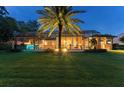 Enclosed backyard with sparkling pool, covered outdoor living and towering palm trees at 4048 Gilder Rose Pl, Winter Park, FL 32792