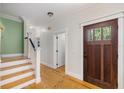 Bright entryway with hardwood floors, white trim, and a wooden door with glass panes at 408 W Pearl St, Minneola, FL 34715