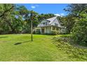 Charming two-story home with white siding, metal roof, wrap-around porch, and lush landscaping at 408 W Pearl St, Minneola, FL 34715