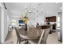Open dining area featuring a modern chandelier, views of the kitchen, and comfortable seating for six at 4432 Desert Rose Ave, Kissimmee, FL 34746