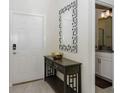 Welcoming entryway featuring a modern mirror, stylish console table with decor, and a glimpse into the adjacent bathroom at 4912 Windermere Ave, Kissimmee, FL 34746