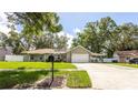 Inviting home with lush green lawn, mature trees, a carport, and a charming mailbox, creating curb appeal at 5177 Chesapeake Ave, Orlando, FL 32808