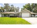 This lovely home features a neatly maintained lawn, solar panels, and an attached two-car garage at 5177 Chesapeake Ave, Orlando, FL 32808