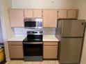 A well-equipped kitchen with stainless steel appliances and light-toned wooden cabinets at 5459 Vineland Rd # 4310, Orlando, FL 32811