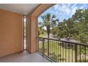 Relaxing balcony with metal railing and views of palm trees and lush landscaping, perfect for outdoor enjoyment at 5512 Metrowest Blvd # 201, Orlando, FL 32811