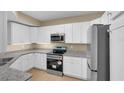Modern kitchen with white cabinets, granite countertops, and stainless steel appliances, offering style and functionality at 5512 Metrowest Blvd # 201, Orlando, FL 32811