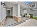 Inviting front porch with stone accents and ample space for seating, leading to an elegant front door at 7834 Minutemen Loop, Winter Garden, FL 34787