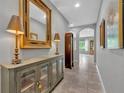 Elegantly decorated hallway with a display cabinet, ornate mirror, and stylish lamps at 7834 Minutemen Loop, Winter Garden, FL 34787