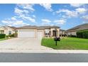 Attractive home featuring a three-car garage and mature landscaping at 8865 Se 119Th St, Summerfield, FL 34491