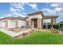 Inviting single-story home showcasing manicured landscaping, a private driveway, and neutral-toned stucco at 8865 Se 119Th St, Summerfield, FL 34491