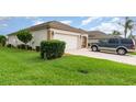 Single-story home featuring lush green lawn, neutral stucco, a two-car garage, and well-maintained landscaping at 8865 Se 119Th St, Summerfield, FL 34491
