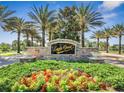Community sign at Eagle Creek featuring stone architecture, lush landscaping, and vibrant floral arrangements at 9533 Mere Pkwy, Orlando, FL 32832