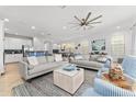 Spacious living room featuring two sofas, ceiling fan, and open access to the kitchen at 1041 Castle Pines Ct, Reunion, FL 34747