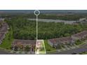 Aerial view of a townhouse property with a lake in the background, surrounded by lush greenery and a peaceful neighborhood at 10656 Savannah Plantation Ct, Orlando, FL 32832