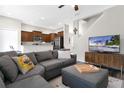 Cozy living room with a sectional sofa, entertainment center with TV, and open view to the kitchen and staircase at 10656 Savannah Plantation Ct, Orlando, FL 32832