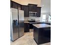 Modern kitchen featuring stainless steel appliances, dark cabinetry and island at 107 Athabasca Dr, Poinciana, FL 34759