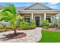 Inviting front entrance with a paved walkway and columns, framed by colorful plants and a healthy palm at 1536 Pine Island Rd, Kissimmee, FL 34744