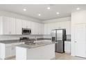 Bright kitchen features white cabinets, granite countertops, stainless steel appliances, and a center island at 1568 Gardiner St, Haines City, FL 33844