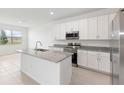 This kitchen is equipped with granite countertops, stainless steel appliances, white cabinets and an island at 1568 Gardiner St, Haines City, FL 33844