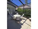 This screened patio features a table with four chairs and a grill, perfect for outdoor dining and entertaining at 160 Calabay Parc Blvd, Davenport, FL 33897