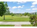 Scenic view of a well-maintained neighborhood park with mature trees and walking paths at 1787 White Feather Loop, Oakland, FL 34787