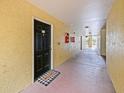 Well-lit hallway leading to unit door with a 