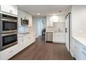 This kitchen features white cabinets, stainless steel appliances, and wood floors at 2325 E Harding Street, Orlando, FL 32806