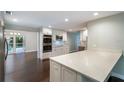 An open concept kitchen is showcased, featuring a spacious quartz island and stainless steel appliances at 2325 E Harding Street, Orlando, FL 32806