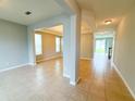 Spacious living room with tile floors, neutral paint, and natural light from large windows at 5107 Longmeadow Park St, Orlando, FL 32811