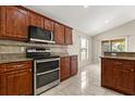 The kitchen features wooden cabinets, stainless steel appliances, and a tiled floor at 5200 Sunset Canyon Dr, Kissimmee, FL 34758