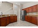 Kitchen with wood cabinets, tile flooring, and granite countertops, adjacent to the staircase at 5200 Sunset Canyon Dr, Kissimmee, FL 34758