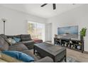Relaxing living room with cozy furniture, a ceiling fan and large bright windows at 555 Jett Ln, Davenport, FL 33837