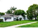 Attractive single-Gathering home featuring a well-manicured lawn, mature trees, and inviting curb appeal at 5607 Spring Run Ave, Orlando, FL 32819