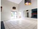 Open living room with tile flooring, modern lighting fixtures, and a sliding door to the pool at 5607 Spring Run Ave, Orlando, FL 32819
