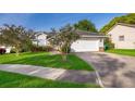 Traditional style home with a two-car garage, manicured lawn, and tidy landscaping at 6512 Grosvenor Ln, Orlando, FL 32835