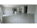 Open-concept living room and kitchen featuring tile flooring and neutral color palette at 680 Sand Pine Ln, Haines City, FL 33844
