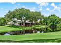 Backyard view of home overlooking water with mature trees providing shade at 6836 Bittersweet Ln, Orlando, FL 32819