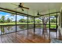 Spacious screened porch features a wooden floor, ceiling fans, and views of the golf course and pond at 6836 Bittersweet Ln, Orlando, FL 32819
