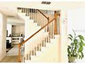 Well-lit staircase with wooden railings, leading to the upper floor of the home at 8206 Gemstone Ct, Orlando, FL 32836