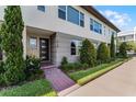 Modern townhome with brick walkway, well-manicured landscaping, and a stylish front door at 10108 Sunnifa Aly, Orlando, FL 32832