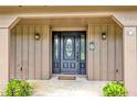 Beautiful front door with glass inlays, welcome decorations, and side sconces at 1071 Deer Run Dr, Winter Springs, FL 32708