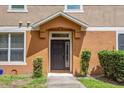 Inviting front entrance with a dark-colored door, decorative plants, and a well-manicured lawn at 1210 San Jacinto Cir, Sanford, FL 32771