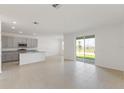 Open floor plan with tile flooring connecting the kitchen to a spacious living area at 1580 Gardiner St, Haines City, FL 33844