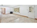 Bright living room featuring a mix of carpet and tile flooring and a large window at 1607 Lindale Ave, Eustis, FL 32726