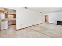 Open living area with tile flooring transitioning to carpet, next to the kitchen at 1607 Lindale Ave, Eustis, FL 32726