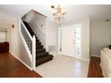Elegant foyer with staircase, chandelier, tile flooring, and a glass-paneled front door at 2205 Wyndam Way, Kissimmee, FL 34743